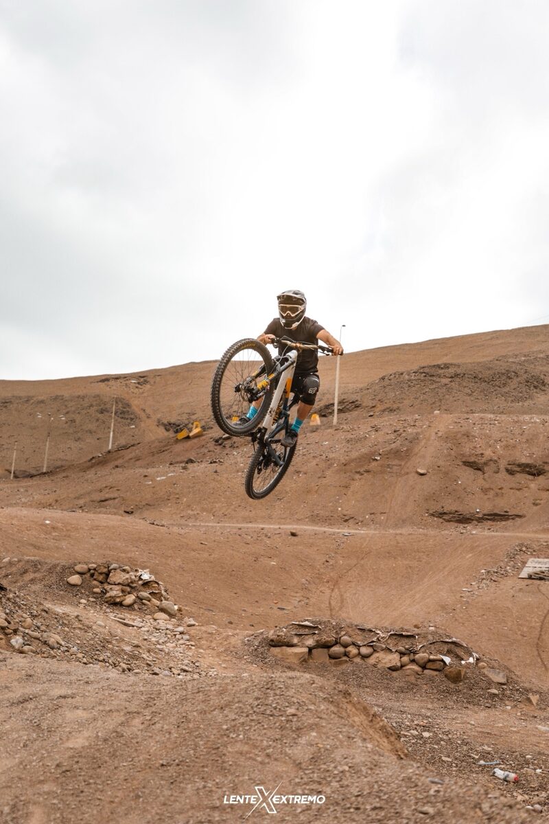 Rider ejecutando un salto durante entrenamiento de downhill